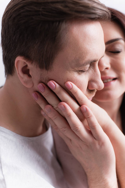 Woman on blurred background touching cheek of husband  - Foto, imagen