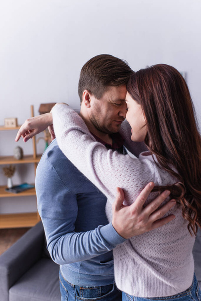 Man hugging brunette wife at home  - Fotografie, Obrázek