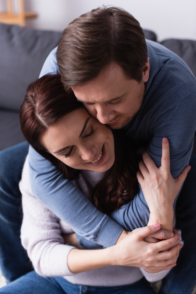 Man hugging happy brunette wife at home  - Valokuva, kuva