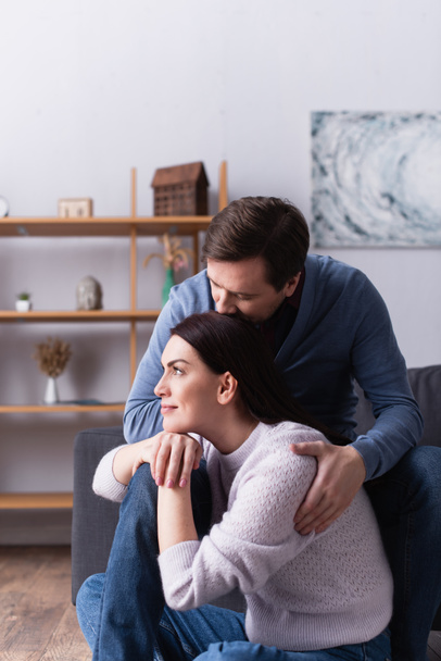 Woman sitting near husband on couch at home  - Foto, imagen