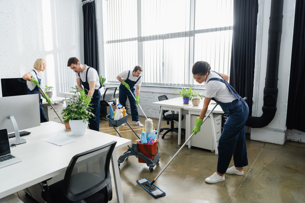 Multiethnic cleaners washing floor together in office  - Photo, Image