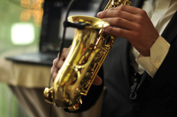 музыкант играет на саксофоне, только руки и инструмент, джаз - Фото, изображение