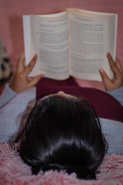 junges Mädchen liest Buch in ihrem Arbeitszimmer aus einer anderen Perspektive - Foto, Bild
