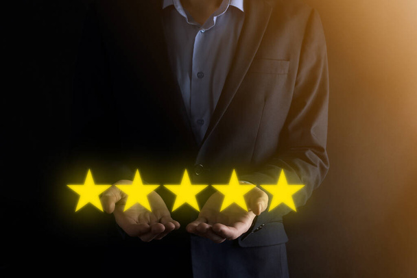 企業の評価を高めるために5つ星のシンボルを指しています。レビュー、評価やランキング、評価と分類の概念 - 写真・画像