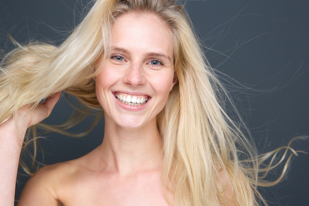 χαμογελώντας ξανθιά κοπέλα με το φύσηγμα μαλλιά - Φωτογραφία, εικόνα