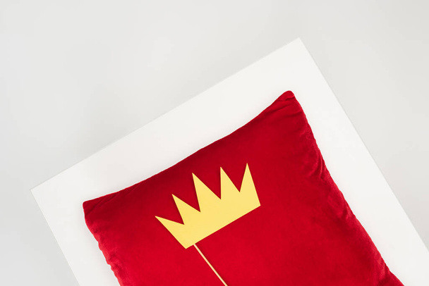 top view of paper crown on stick and red pillow isolated on grey - Photo, Image