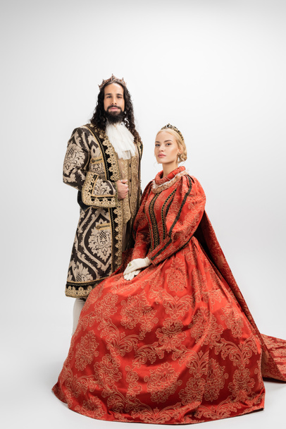 full length of historical interracial couple in crowns on white - Photo, Image