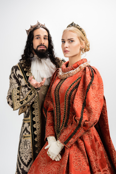rey y reina interracial en ropa medieval y coronas aisladas en blanco - Foto, imagen