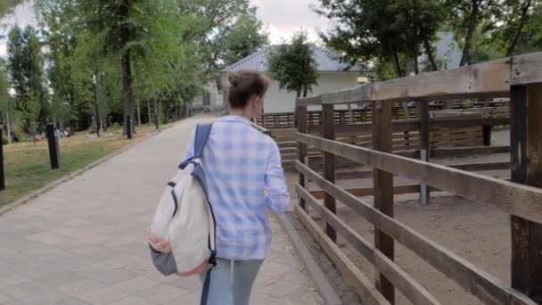 Mulher com mochila urbana andando na rua perto da fazenda da cidade - câmera lenta - Filmagem, Vídeo