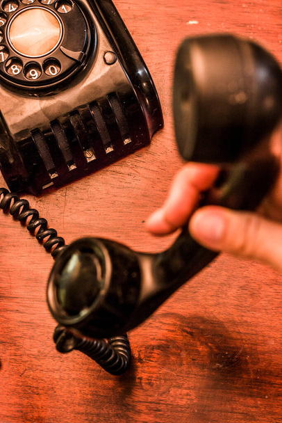Παλιό μαύρο vintage dial-up τηλέφωνο σε ξύλινο τραπέζι. Εναέρια βολή - Φωτογραφία, εικόνα