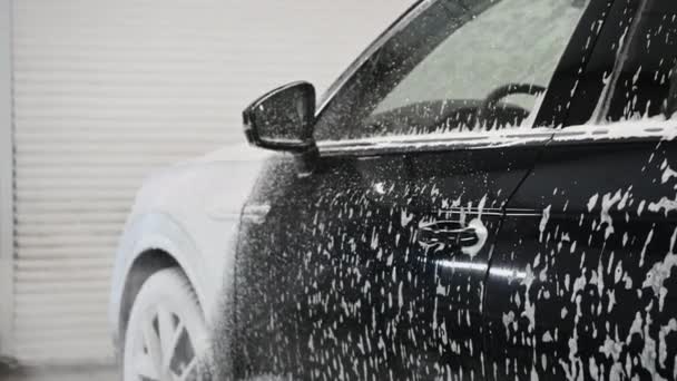 Процес миття автомобілів. Піноутворюючий миючий засіб покриває сторону автомобіля, очищає його від бруду і пилу
. - Кадри, відео