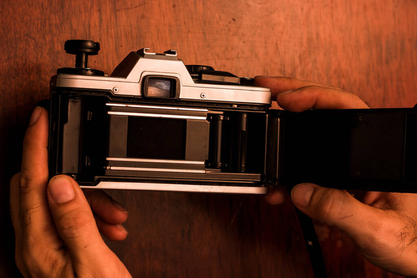 Cámara analógica de estilo vintage con la tapa trasera abierta lista para insertar un rollo de película. Disparo aéreo - Foto, Imagen
