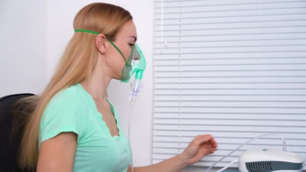 Крупный план молодой женщины с помощью респираторной маски вдыхая лекарства, чтобы очистить ее горло и пазухи. Коронавирусное лечение. - Кадры, видео