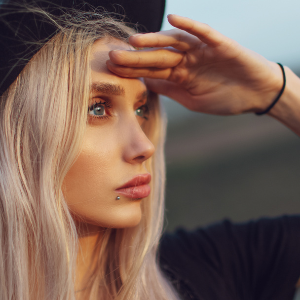 Close-up portrait of young blonde girl with blue eyes looking away. - Photo, Image
