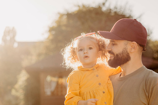 Stylish bearded father holding his little curly daughter - Zdjęcie, obraz