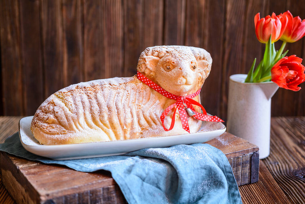Torta classica di agnello pasquale cosparsa di zucchero a velo su fondo di legno - Foto, immagini