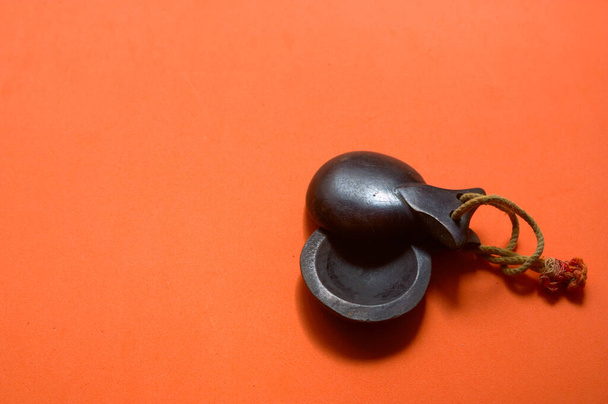 Close-up of some traditional dark wood castanets of Spanish music on an orange background with copy space - Photo, Image