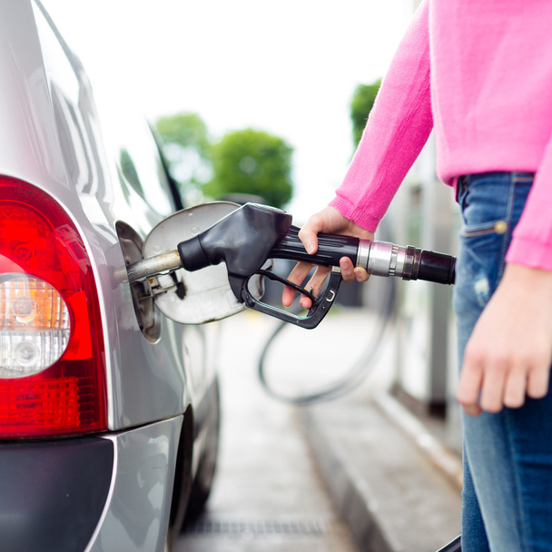 Frau pumpt Benzin in Auto an Tankstelle. - Foto, Bild