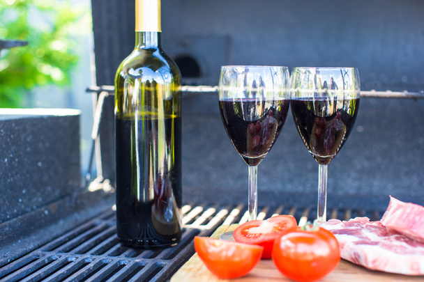 dvě sklenice červené víno, steak a rajčaty na grilu venku - Fotografie, Obrázek