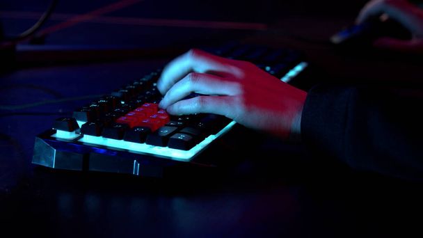 Las manos de un jugador masculino durante un juego tenso, el teclado y el ratón son visibles. - Foto, Imagen