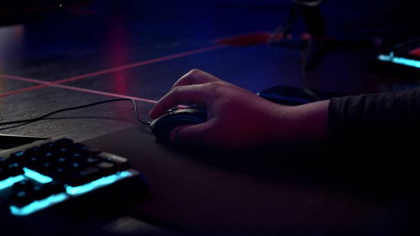 Uma visão de perto da mão de um homem que usa e rola o mouse ao lado do teclado - Foto, Imagem