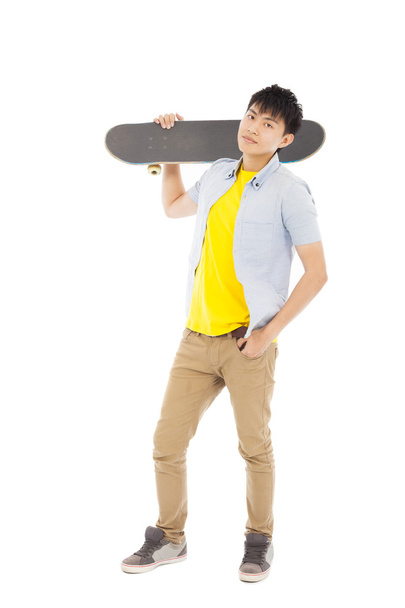 jeune homme confiant debout et tenant un skateboard
  - Photo, image