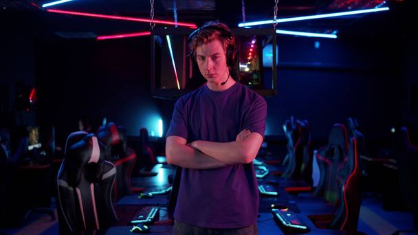 Před začátkem kybernetického turnaje, mladý hráč pózuje na pozadí svých týmů hracích míst - Fotografie, Obrázek