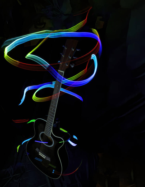 siluetti akustinen kitara pimeässä valaistu polkuja värillinen valo, maalaus valo, värilliset valot, pitkä valotus, pystysuora - Valokuva, kuva