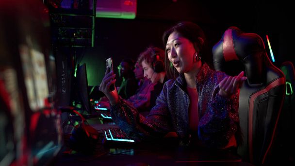 Uma garota muito streamer está transmitindo no twitch de um torneio de estratégia mmorpg entre os jogadores de esports, câmera lenta - Foto, Imagem