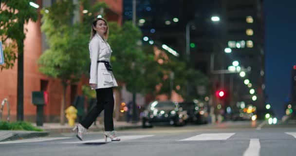 Μια γυναίκα με αυτοπεποίθηση με ρούχα σχεδιαστών στη νυχτερινή πόλη. Μοντέλο σε κομψό ντύσιμο 4K - Πλάνα, βίντεο
