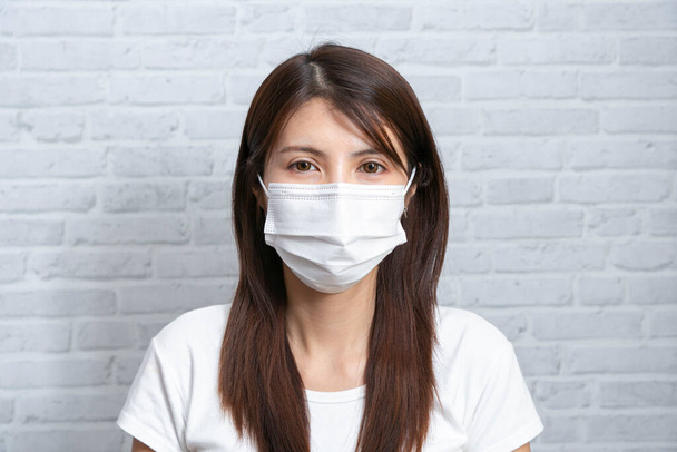 Азійська молода жінка носить медичну маску, яка захищає від поширення коронавірусу або хвороби COVID-19.. - Фото, зображення