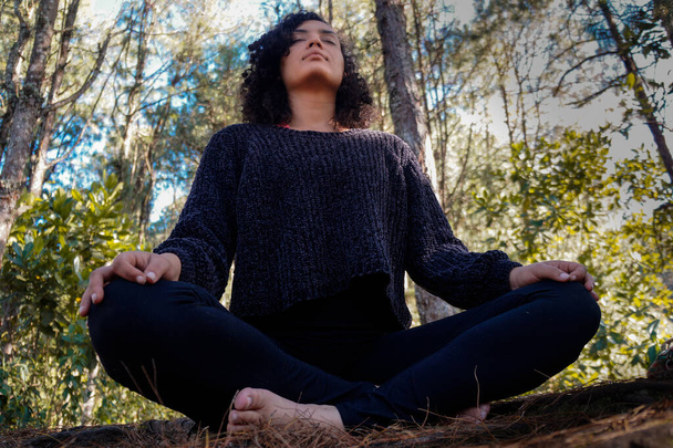 Молодая женщина в позе медитации в лесу - Фото, изображение