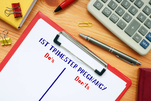 Concepto de negocio que significa 1ST TRIMESTER PREGNANCY Do 's and Don' t with sign on the sheet - Foto, Imagen