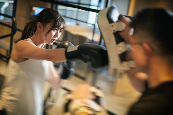 Mujer asiática aprendiendo kickboxing de un entrenador personal - Foto, imagen