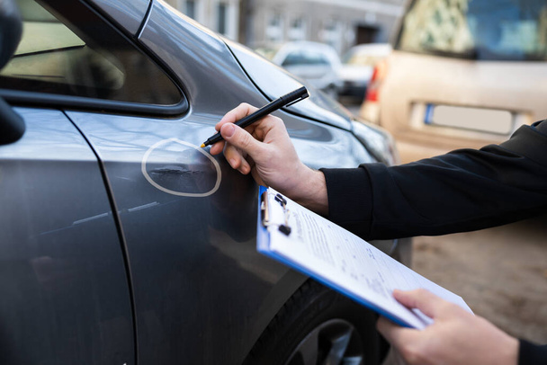 Insurance Agent Or Adjuster Inspecting Car After Accident - 写真・画像