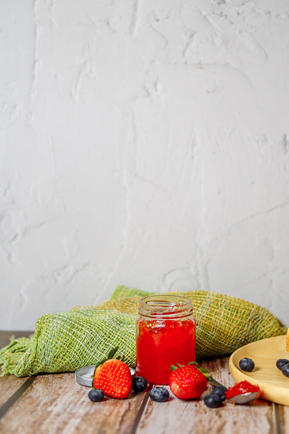 Confiture de fraises et de fraises sur une table en bois - Photo, image