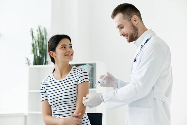 médico masculino que administra una inyección a una mujer salud de la vacunación  - Foto, Imagen