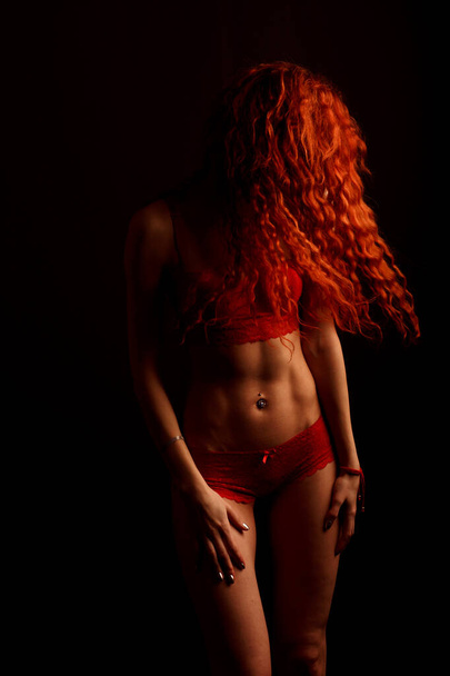 Σέξι γυναίκα με εσώρουχα σε μαύρο φόντο, κόκκινα μαλλιά - Φωτογραφία, εικόνα