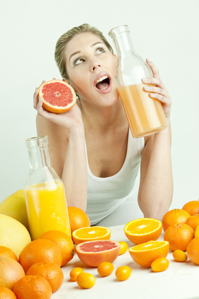 πορτρέτο της νεαρής γυναίκας με εσπεριδοειδή και χυμό πορτοκαλιού - Φωτογραφία, εικόνα