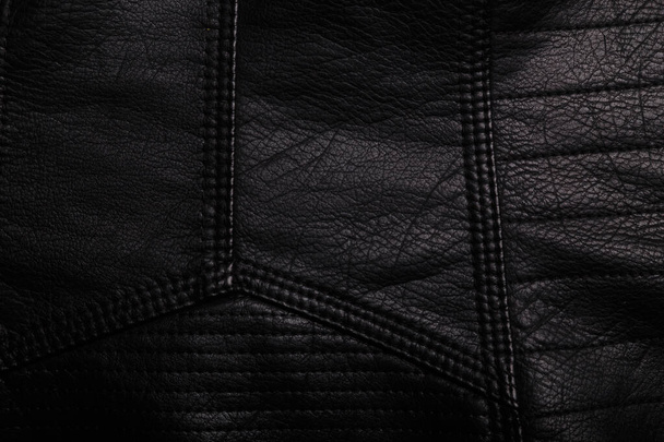 Black leather jacket texture with seams. Background or backdrop, clothing surface. - Photo, Image