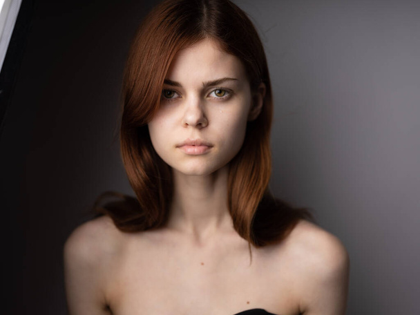 Πορτρέτο όμορφη γυναίκα δεν μακιγιάζ με γυμνούς ώμους κόκκινα μαλλιά close-up γκρι φόντο περικοπή άποψη - Φωτογραφία, εικόνα