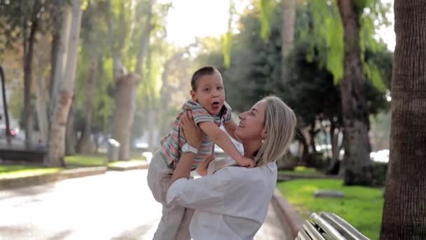 Happy mom play with her son during they walking outdoors. Kid with physical diability. Video of enjoy happy love family outdoors. Happy moments. Disability care concept - Footage, Video