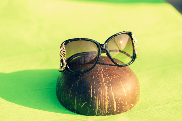 Модні сонцезахисні окуляри коричневого кольору модель для жінок зі спеціальною дизайнерською стрічкою зовні в літній день. Вибірковий фокус
  - Фото, зображення
