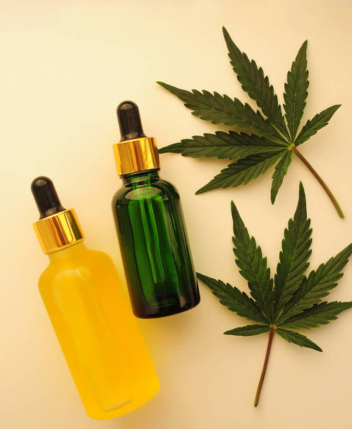Cannabis leaves, cbd oil, cosmetic cream. Marihuana extract in cosmetology. Flat lay, powder background. Home relaxation, spa recreation, pastime therapy. - Photo, Image