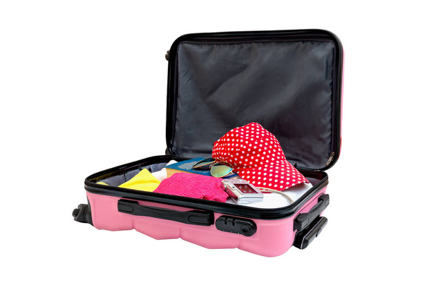 Відкрита рожева валіза з речами для решти, ізольована на білому. Сімейна дорожня сумка упакована у відпустку. Багаж повний одягу, концепція подорожі
 - Фото, зображення