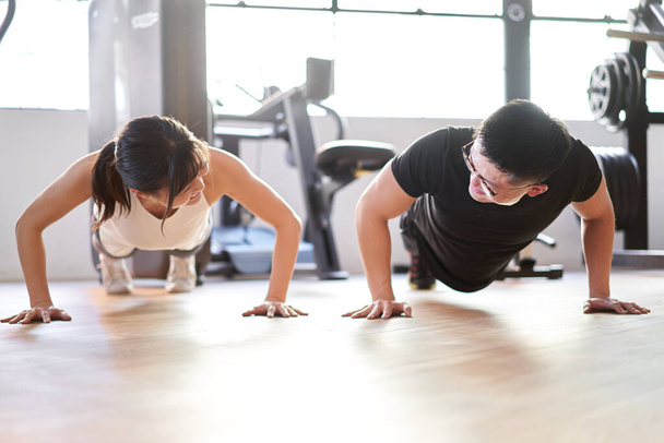 Asian couple doing push-ups in pairs - Photo, Image