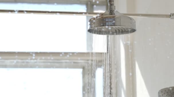 ducha detrás de la ventana de vidrio húmedo con gotas de agua salpicaduras. Agua corriendo desde la cabeza de la ducha y el grifo - Imágenes, Vídeo