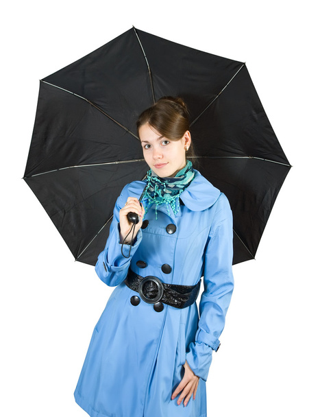 Beautiful young woman wearing blue coat holding black umbrella, isolated on white background. - Foto, Imagem