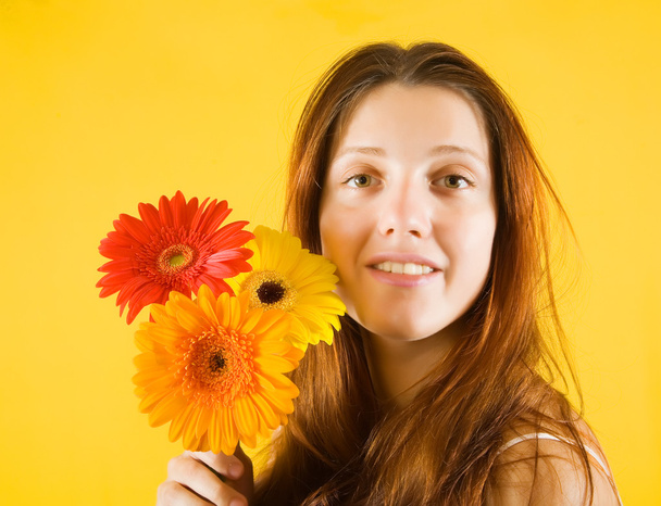 Girl with flowers over yellow - Fotoğraf, Görsel