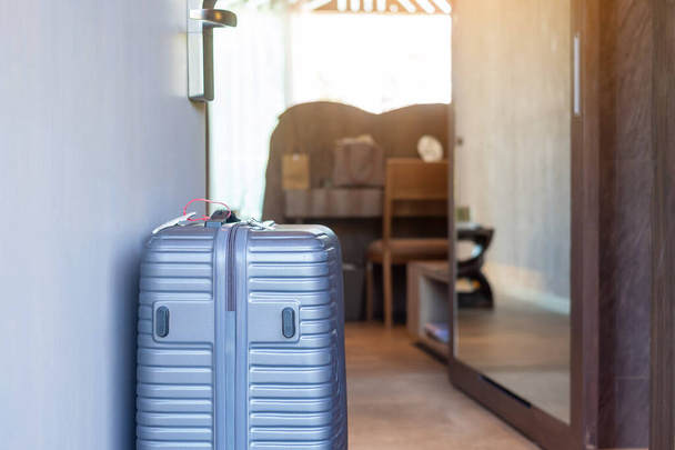 Сірий багаж в сучасному готельному номері за дверима. Час подорожувати, подорожувати, подорожувати та відпочивати. - Фото, зображення